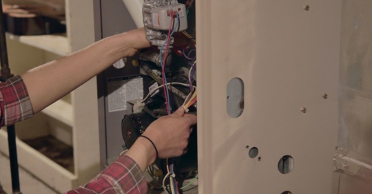 HVAC technician working on furnace