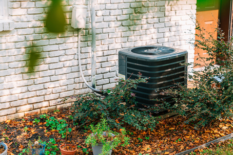 an HVAC system beside the brick wall